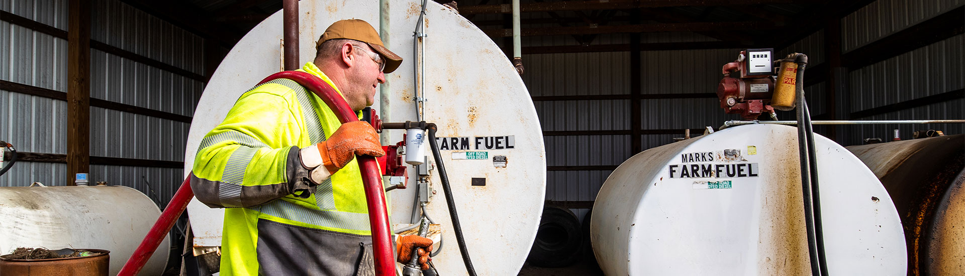 Man carrying hose to fill fuel tanks