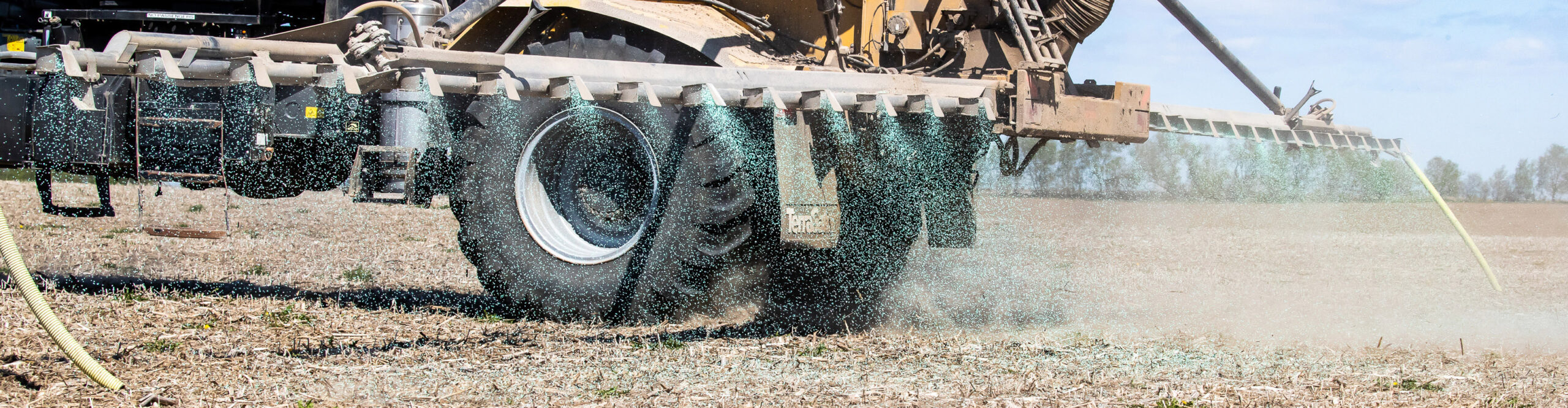 Tractor spraying crop nutrients in a field