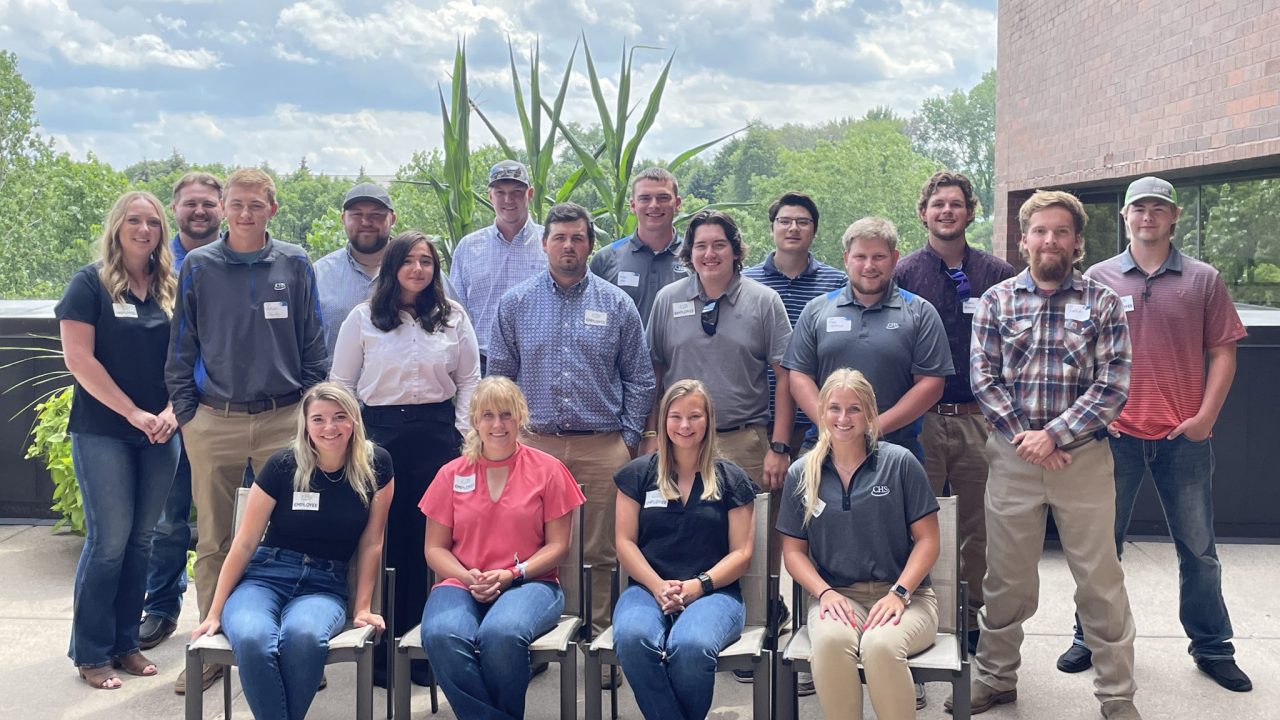 Group of college interns standing and sitting on an outdoor patio
