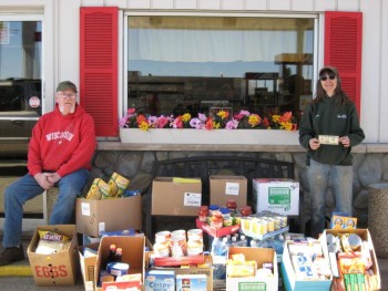Man and woman beside boxes filled with dry pantry food donations