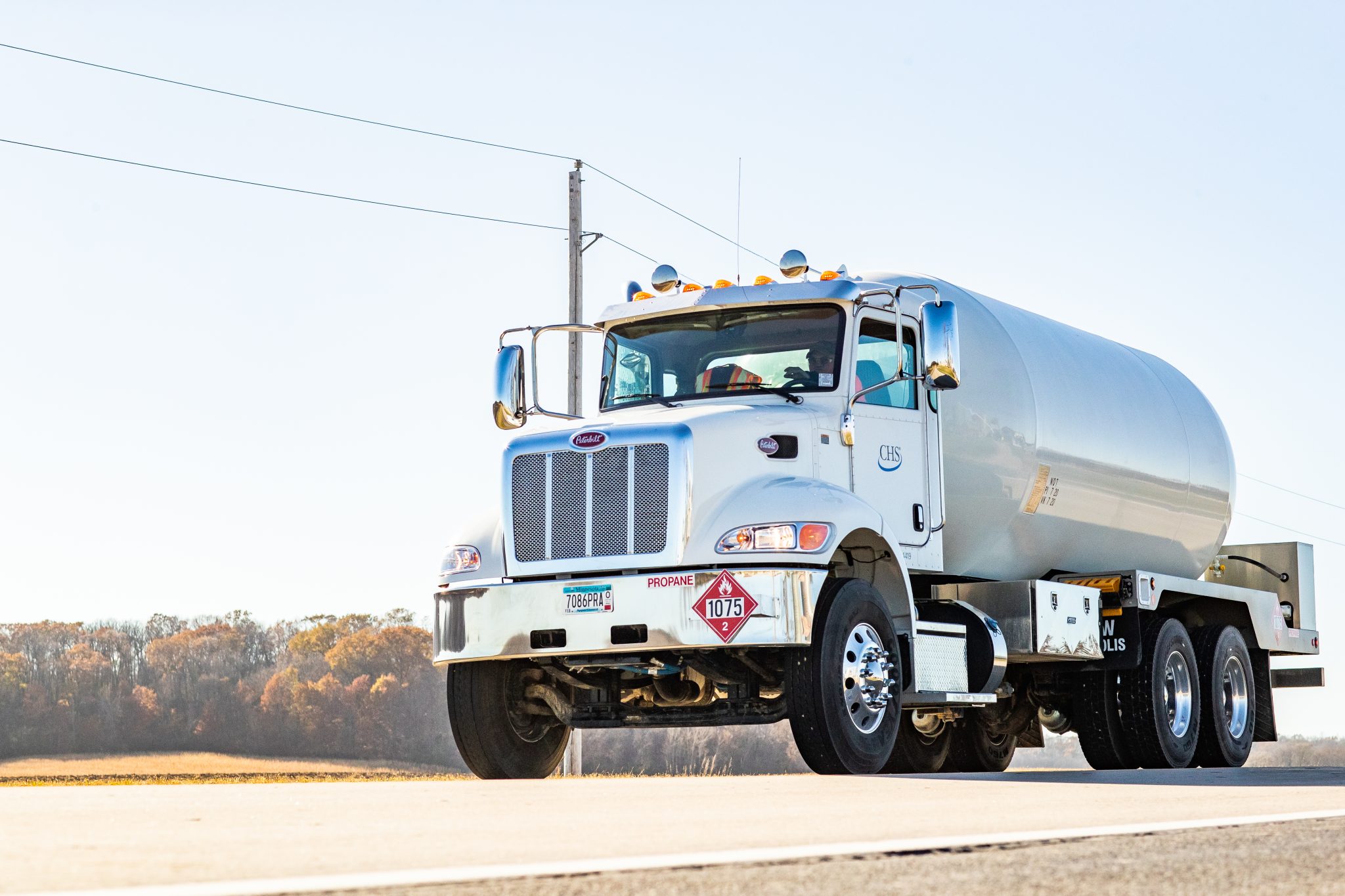 Propane truck driving down a country road